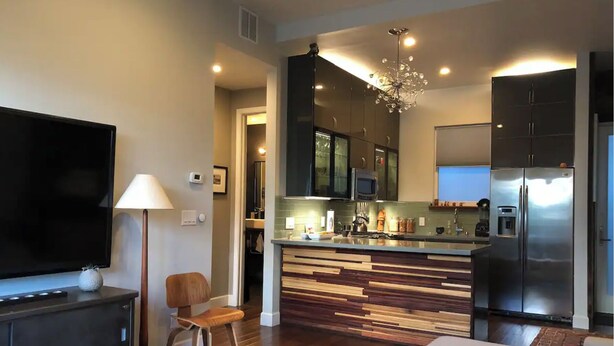 A modern kitchen with a central island, a built-in microwave, and a stainless steel refrigerator. - Beautiful Cottage, hot tub, in great neighborhood (San Francisco)