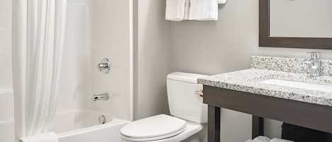 A modern bathroom with a shower, toilet, and sink.