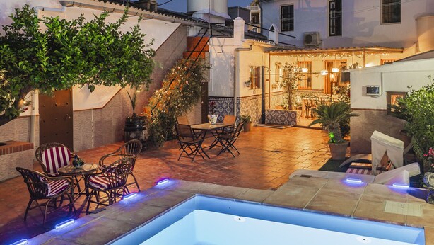 Ein Innenhof mit Pool, Sitzgelegenheiten im Freien und einer Treppe.