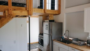 Eine kleine Küche mit Einbauofen, Kühlschrank und Spüle.