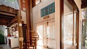 A spacious interior with a wooden staircase, a kitchen area, and large windows. - CASA Ecológica Paraty (Paraty)