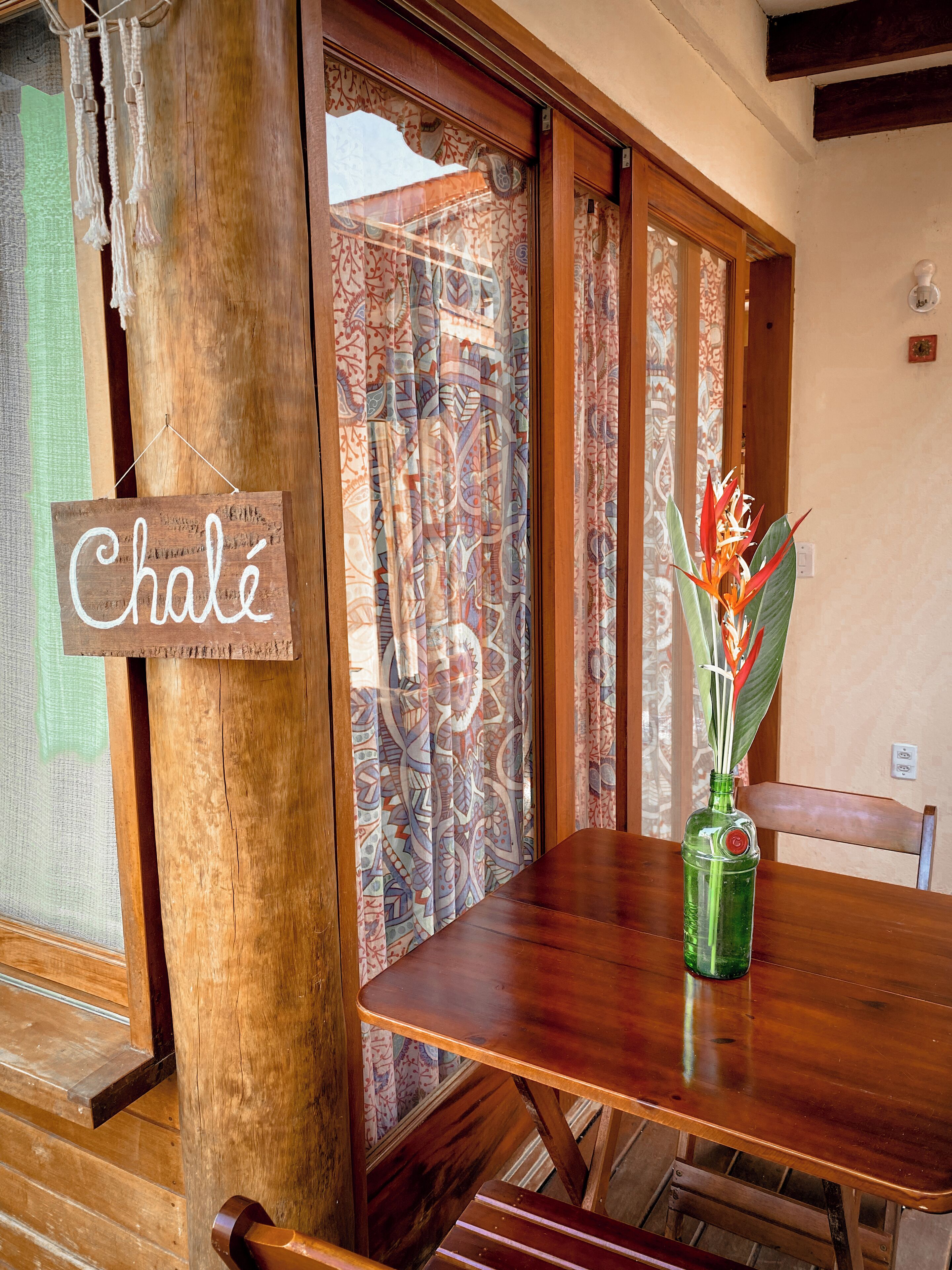 Una mesa de madera con una botella verde y un letrero que dice 'Chalet'.