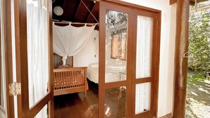 A wooden deck leading to a bedroom with a bed, a crib, and a hanging chair. - CASA Ecológica Paraty (Paraty)