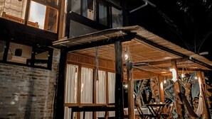 A two-story building with large windows and a covered outdoor seating area with tables and chairs. - CASA Ecológica Paraty (Paraty)