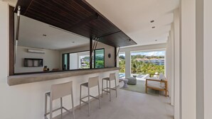 Una cocina moderna con una isla grande, taburetes de bar y vistas a la ciudad.