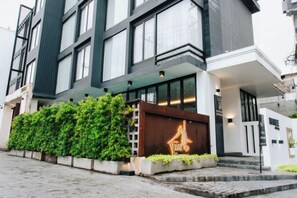 Un bâtiment moderne doté d’une grande entrée, d’un jardin bien entretenu et d’une enseigne bien visible.