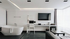 Un baño moderno con una bañera independiente, un tocador blanco y un espejo grande.