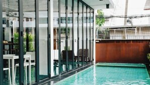 Una piscina con paredes de vidrio, asientos interiores y vistas del entorno.