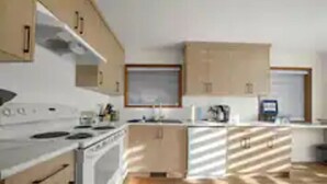 A modern kitchen with white cabinets, a stove, and a sink.