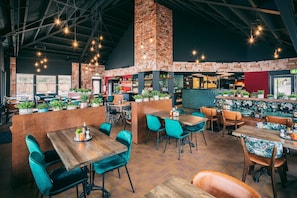A restaurant with wooden tables and chairs, brick walls, and hanging lights. - Villa in Weerterbergen With Private Sauna (Weert)