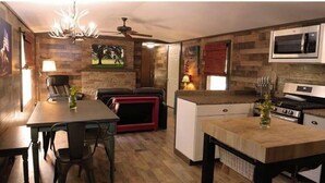 Cocina compacta con microondas, estufa y comedor.