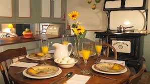Une table à manger dressée avec des assiettes, des verres, un pichet et un bol d’œufs.