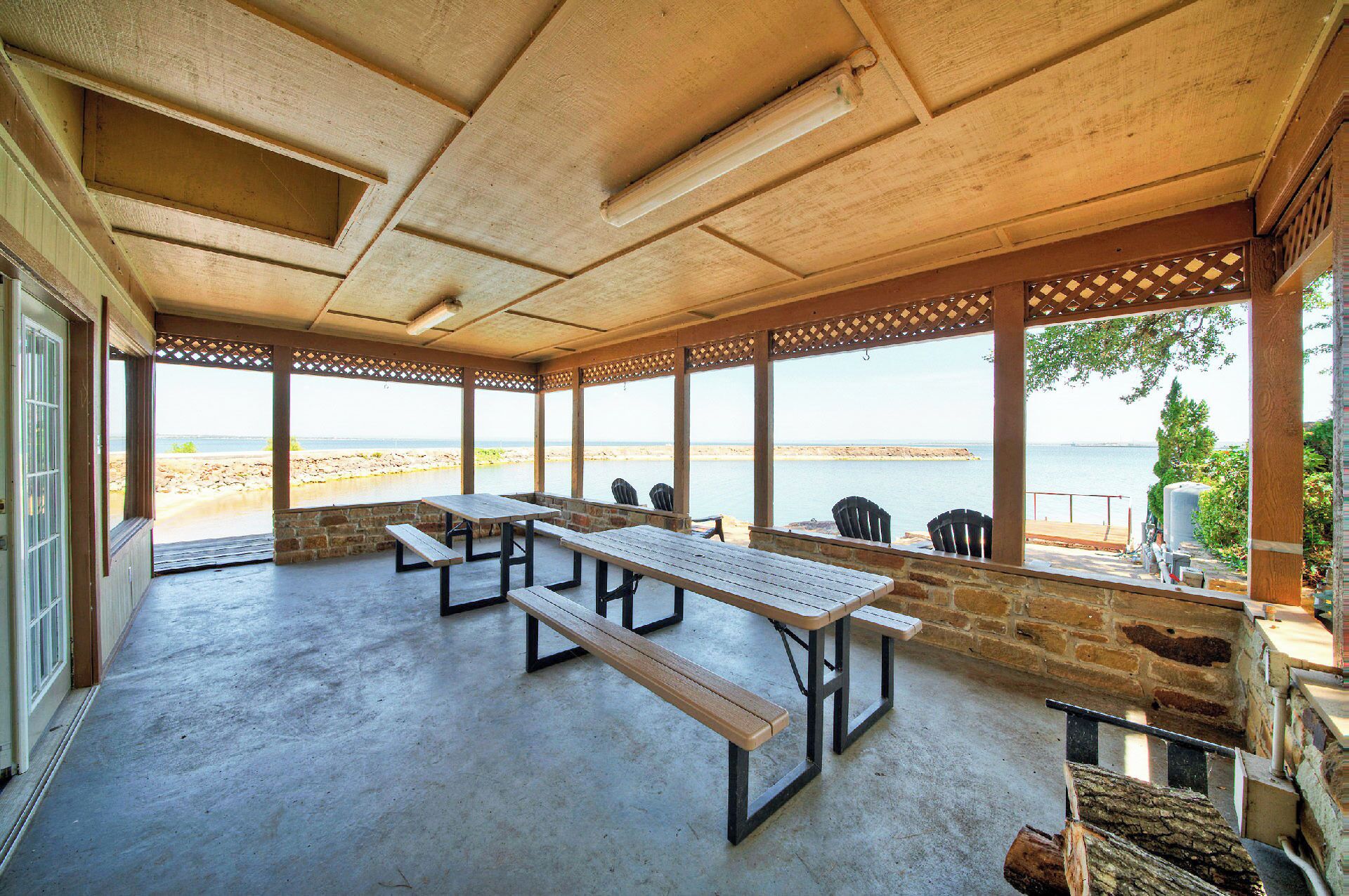 Un espace extérieur abrité, aménagé avec des sièges, et offrant une vue sur la plage et la mer.