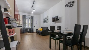 A modern living space with a dining area, kitchen, and a sofa. - Turin World Apartment by Wonderful Italy (Turin)
