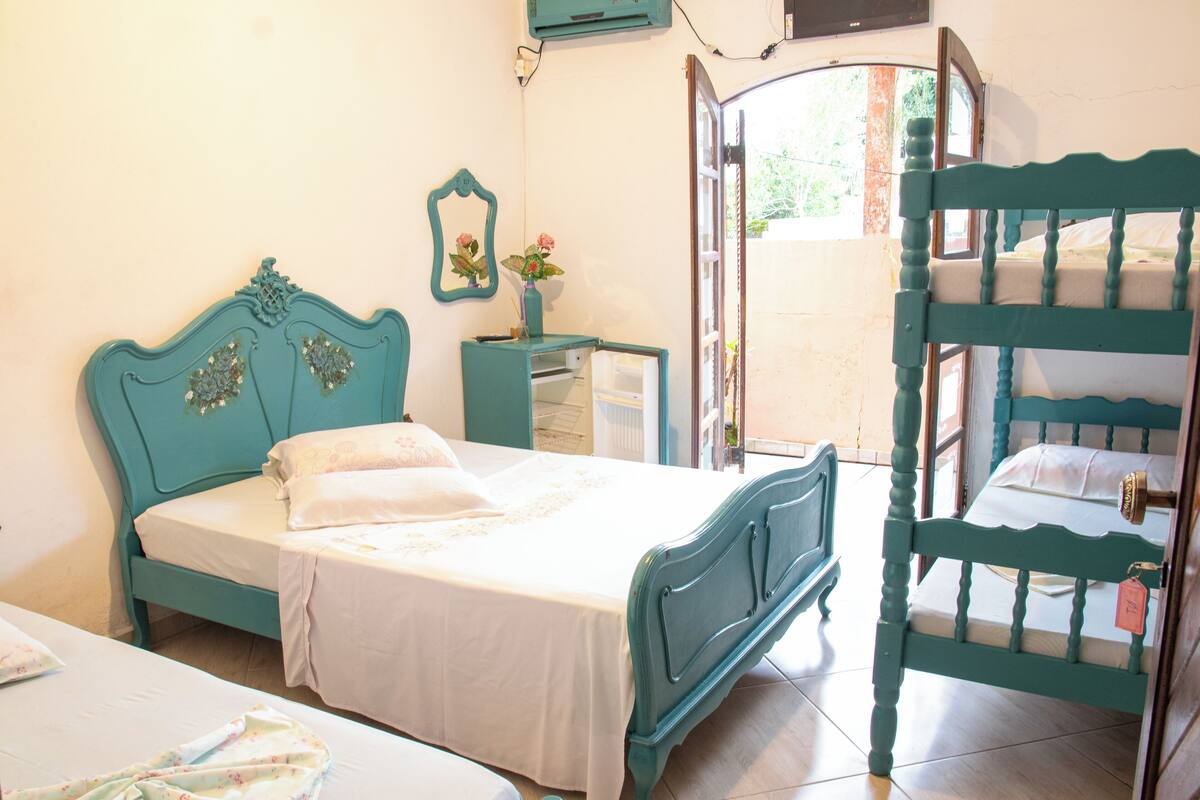 Une chambre avec un lit, une commode et un lit superposé.