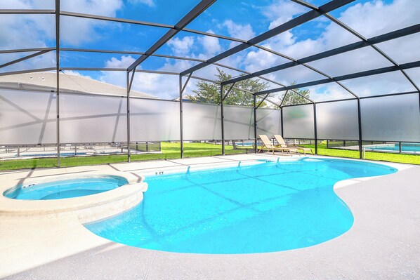 A swimming pool with a sunken hot tub, surrounded by a covered area with a metal frame and glass panels. - 20 Guest Family Mansion at Sonoma Resort (Kissimmee)