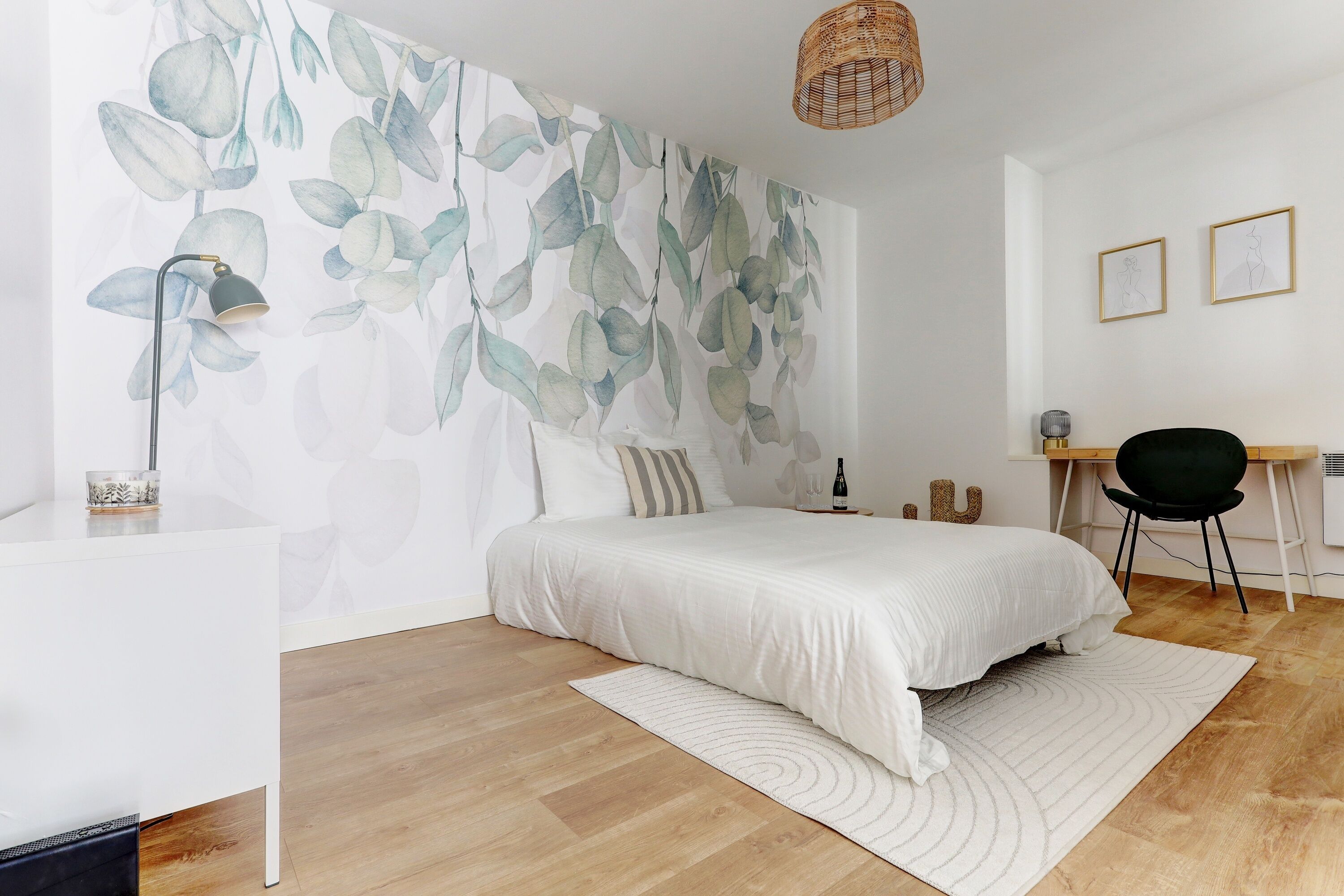A modern bedroom with a large bed, a desk, and a chair.