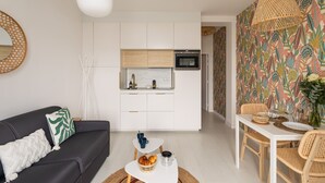 Un salon moderne avec un canapé, une table basse et un coin repas.