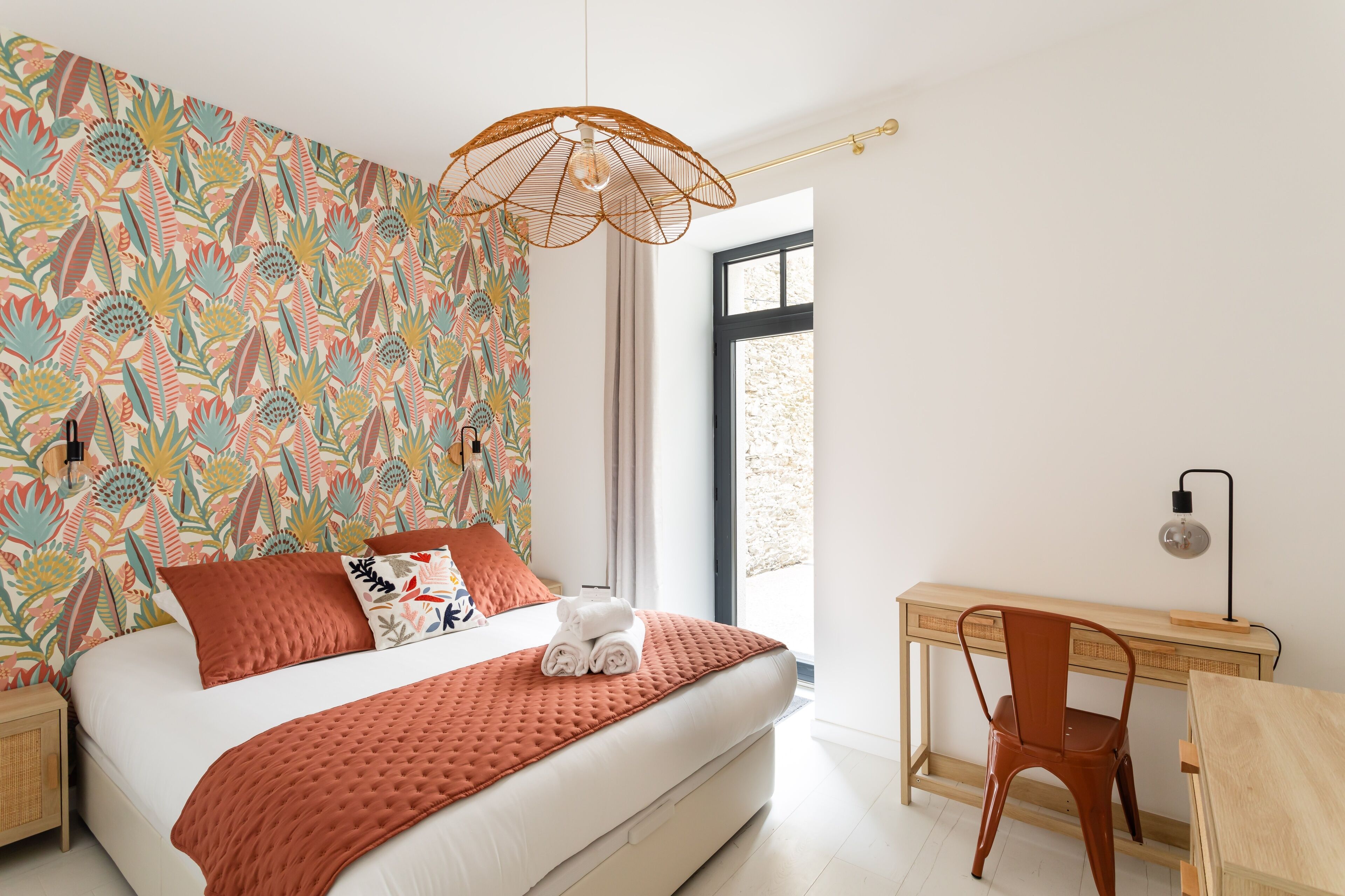 A bedroom with a bed, a desk, and a chair.