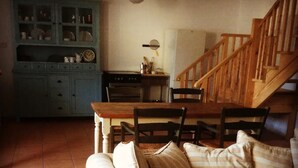 A cozy living room with a striped sofa, wooden dining table, and a staircase. - The Coach house of Durhamstown Castle

 (Bohermeen)