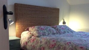 A bedroom with a bed, a nightstand, a lamp, and a radiator. - The Coach house of Durhamstown Castle

 (Bohermeen)