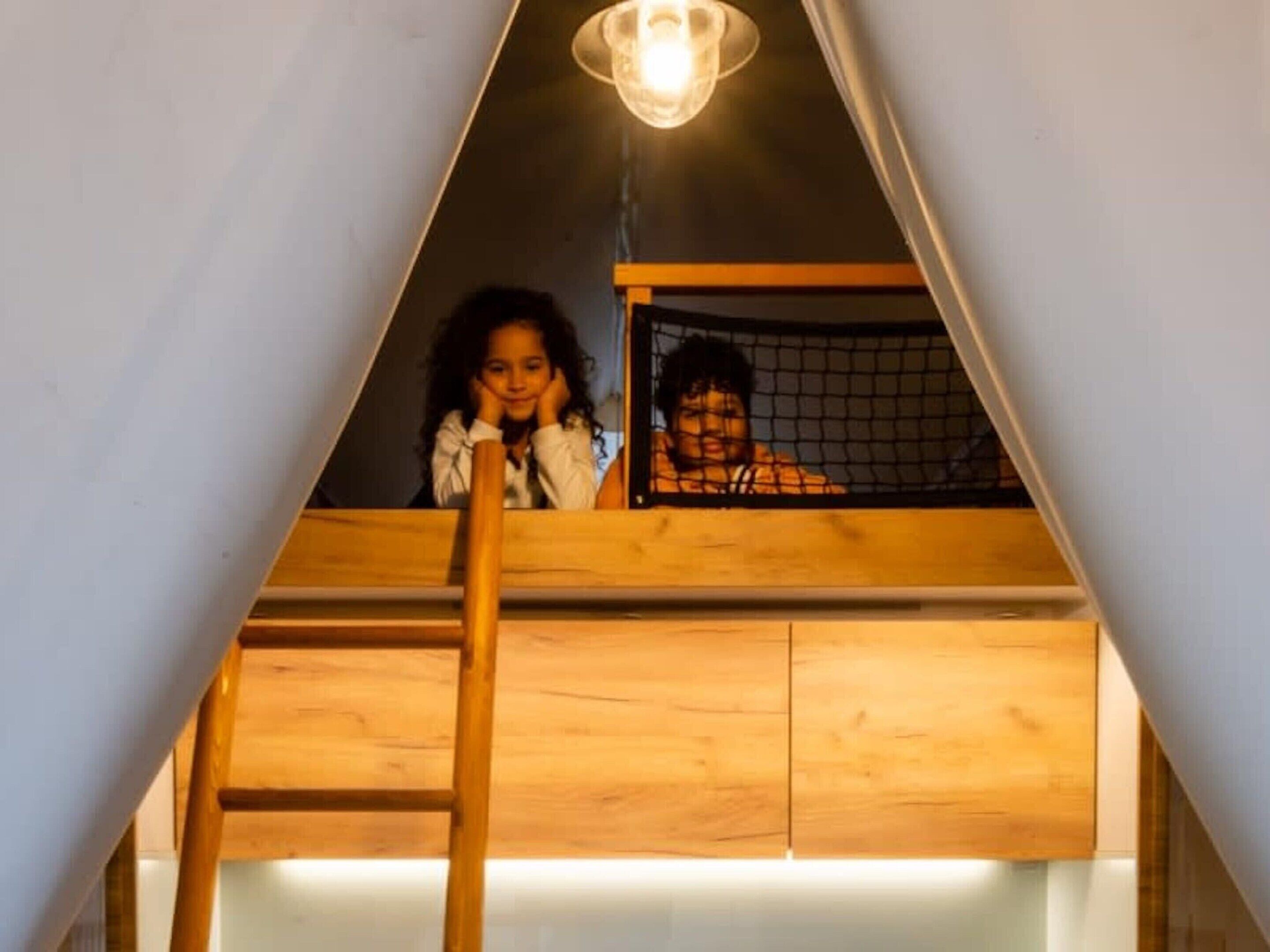 Dormitorio estilo loft con escalera que sube a un techo inclinado.
