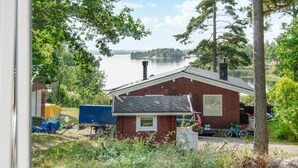 A small cabin with a stone roof, surrounded by trees and a lake. - Pet friendly home in Mariefred with WiFi (Mariefred)