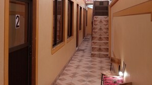 A corridor with a tiled floor, a staircase, and a sign indicating a WiFi zone. - hostal beds of salt ga (Uyuni)