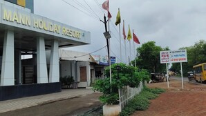 A hotel named 'TEL MANN HOLIDAY RESORT' with a modern facade, a covered entrance, and a signboard in a foreign language. - Mann Holiday Resort (Burhanpur)
