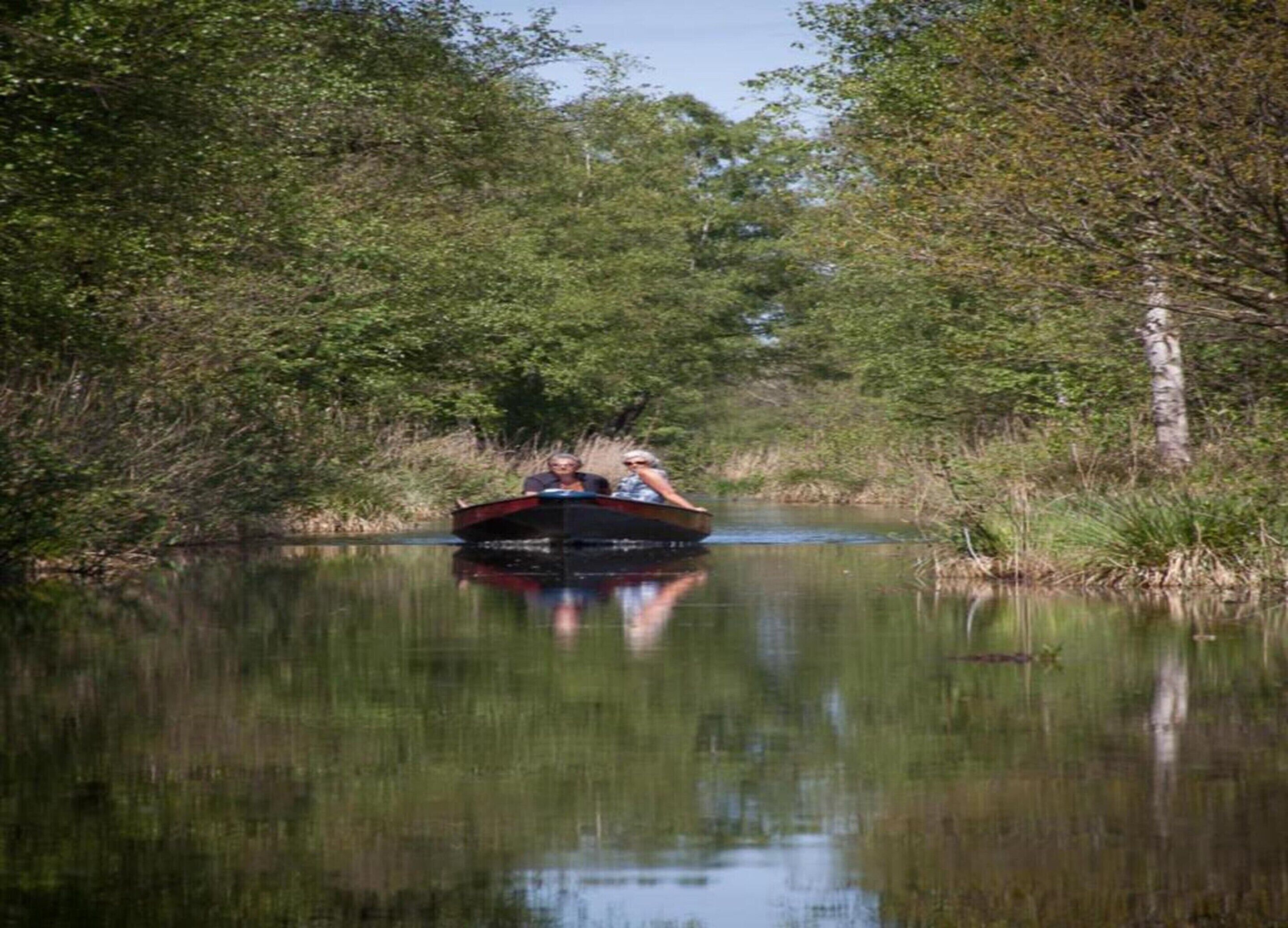 A narrow waterway with dense greenery on both sides.