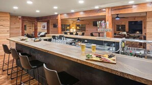 A bar area with a long counter, stools, and a variety of drinks and food items. - EML 6 Hidey-Hole (Paonia)