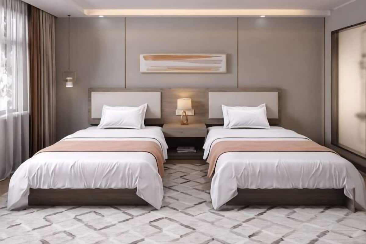 A hotel room with two beds, a nightstand with a lamp, a large window with curtains, and a geometric patterned floor.