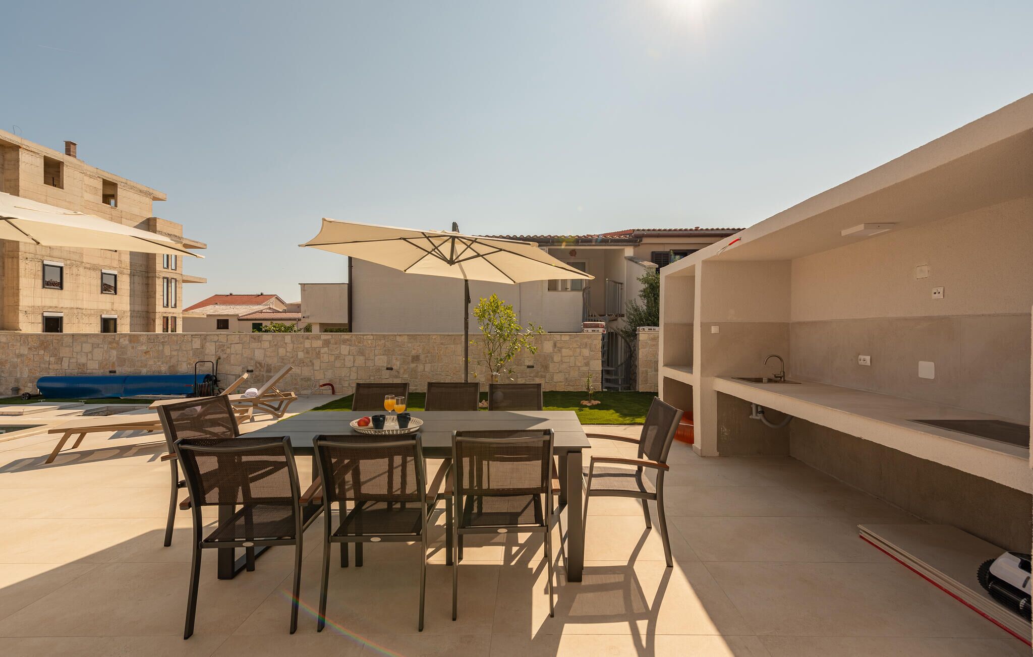 An outdoor patio with a table, chairs, and a large umbrella.