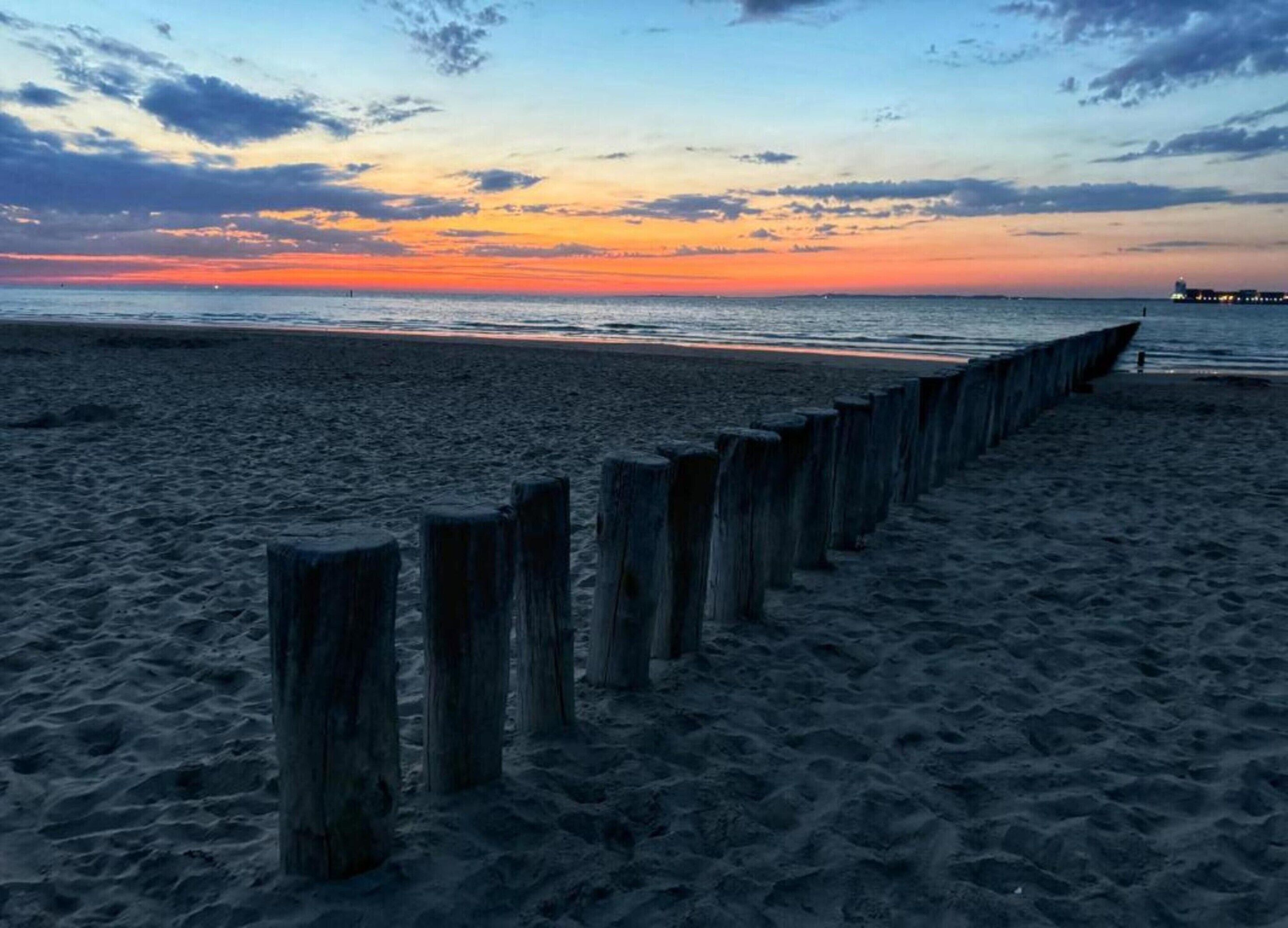 Ein Strand mit Holzpfählen entlang der Küste.