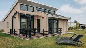 A modern two-story house with a patio, large windows, and a flat roof. - Private Indoor Pool Home in Verviers (Breskens)