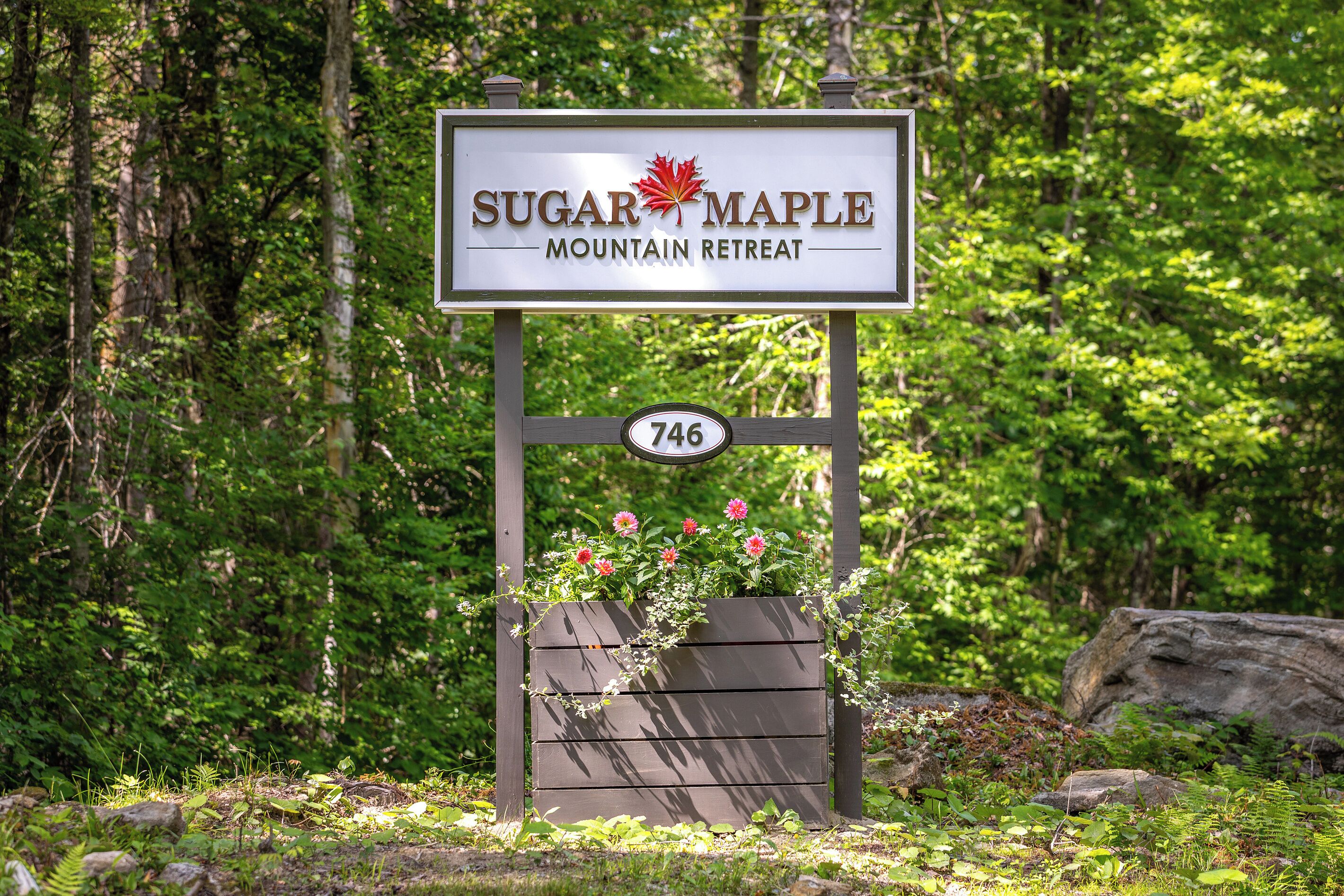 A sign for Sugar Maple Mountain Retreat with a number 746.