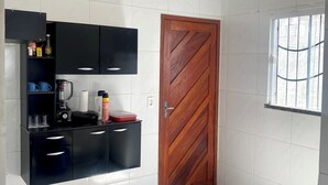 Une cuisine moderne avec des meubles de couleur noire, une porte en bois et une cuisinière à gaz.