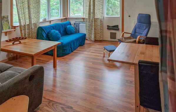 A cozy room with a blue sofa, a wooden table, and a blue chair. - 2 bedroom lovely home in Ankarsrum (Ankarsrum)