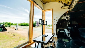 A room with large windows, a table, and a view of the outdoors. - Iconic 727 Jet: Private Aft Suite + Lounge (Houston)