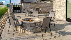 An outdoor patio with stone walls, a fire pit, and outdoor seating. -  Fairfield Inn & Suites by Marriott® Norwalk Des Moines (Norwalk)