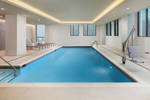 Una piscina techada, sillones reclinables de piscina