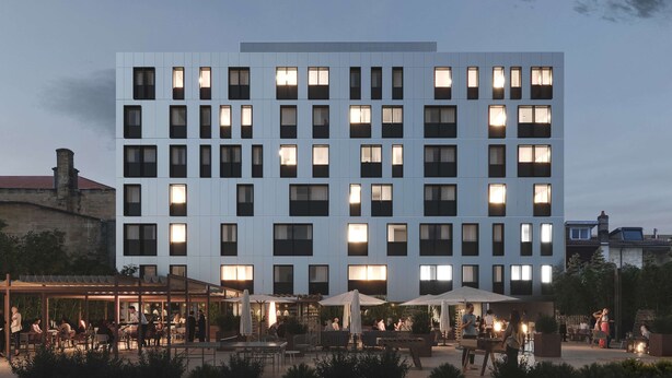 Een modern hotel met meerdere verdiepingen, buiten zitplekken en een overdekt terras.