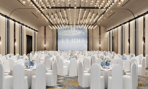 A large, well-lit banquet hall with rows of round tables set for a formal event, featuring a backdrop with the text 'CURIO COLLECTION BY HILTON'. - Chongqing Lijia Baiyun Lake Hotel, Curio Collection Hilton (Chongqing)