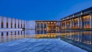 Ein modernes Gebäude mit einem spiegelnden Pool und Glasgeländern.
