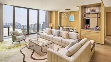 A modern living room with a sofa, armchair, coffee table, and a dining area with a table and chairs.