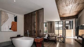 A modern bathroom with a freestanding bathtub, wooden paneling, and a large window.