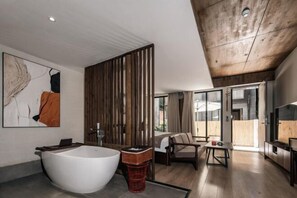 A modern bathroom with a freestanding bathtub, wooden paneling, and a large window. - Jingli Yisu Inn (Lijiang)