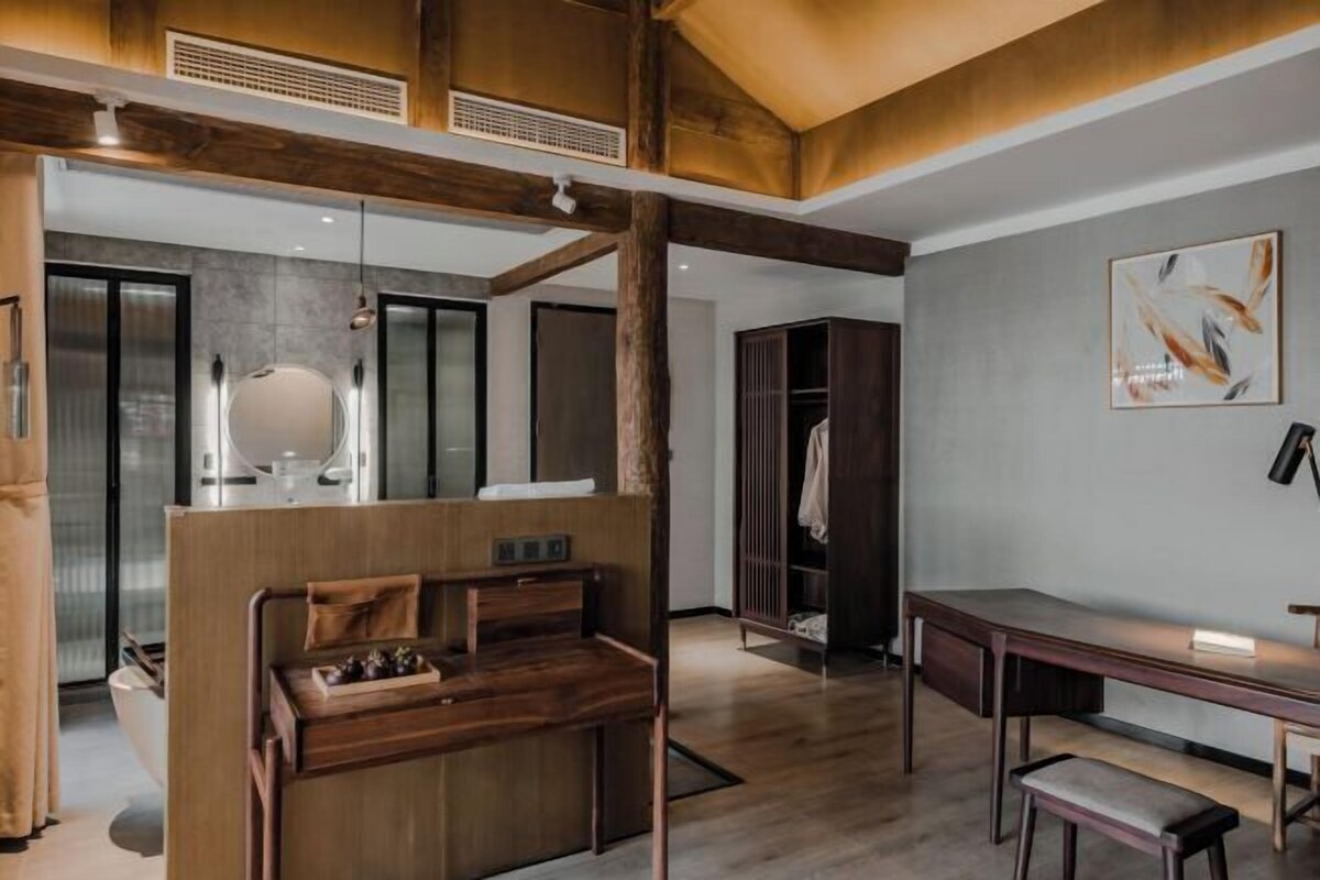 A modern interior with a wooden desk, a bench, and a wardrobe.