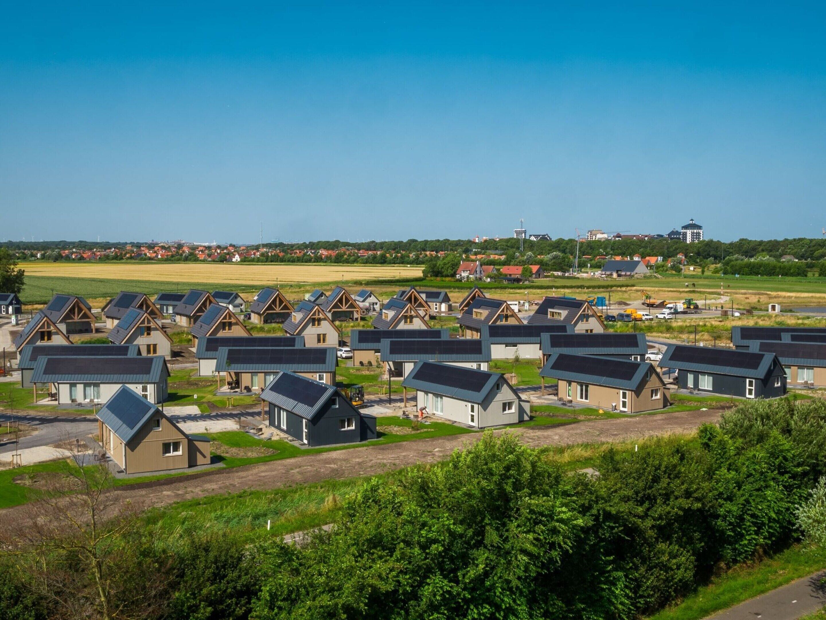 A residential area with multiple houses featuring pitched roofs and solar panels.