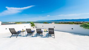 A rooftop terrace with four lounge chairs, a small table, and a potted plant. - Gorgeous home in Privlaka (Privlaka)